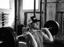 Load image into Gallery viewer, PHYSICAL Fighter Low Profile Mesh Back Trucker Hat — lifting — black and white editorial